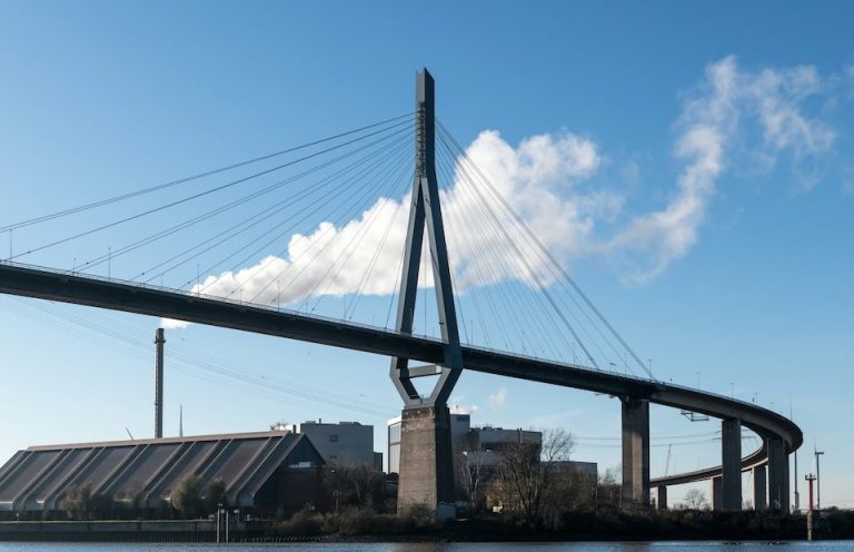 Moderne Brücke vor Bürogebäude als Symbol für betriebliche Gesundheitsförderung.