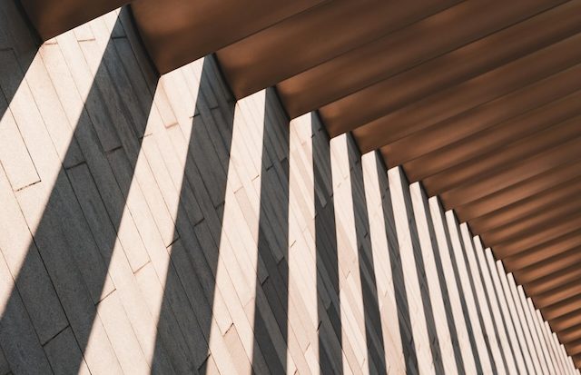 Moderne Brücke vor Bürogebäude als Symbol für betriebliche Gesundheitsförderung.