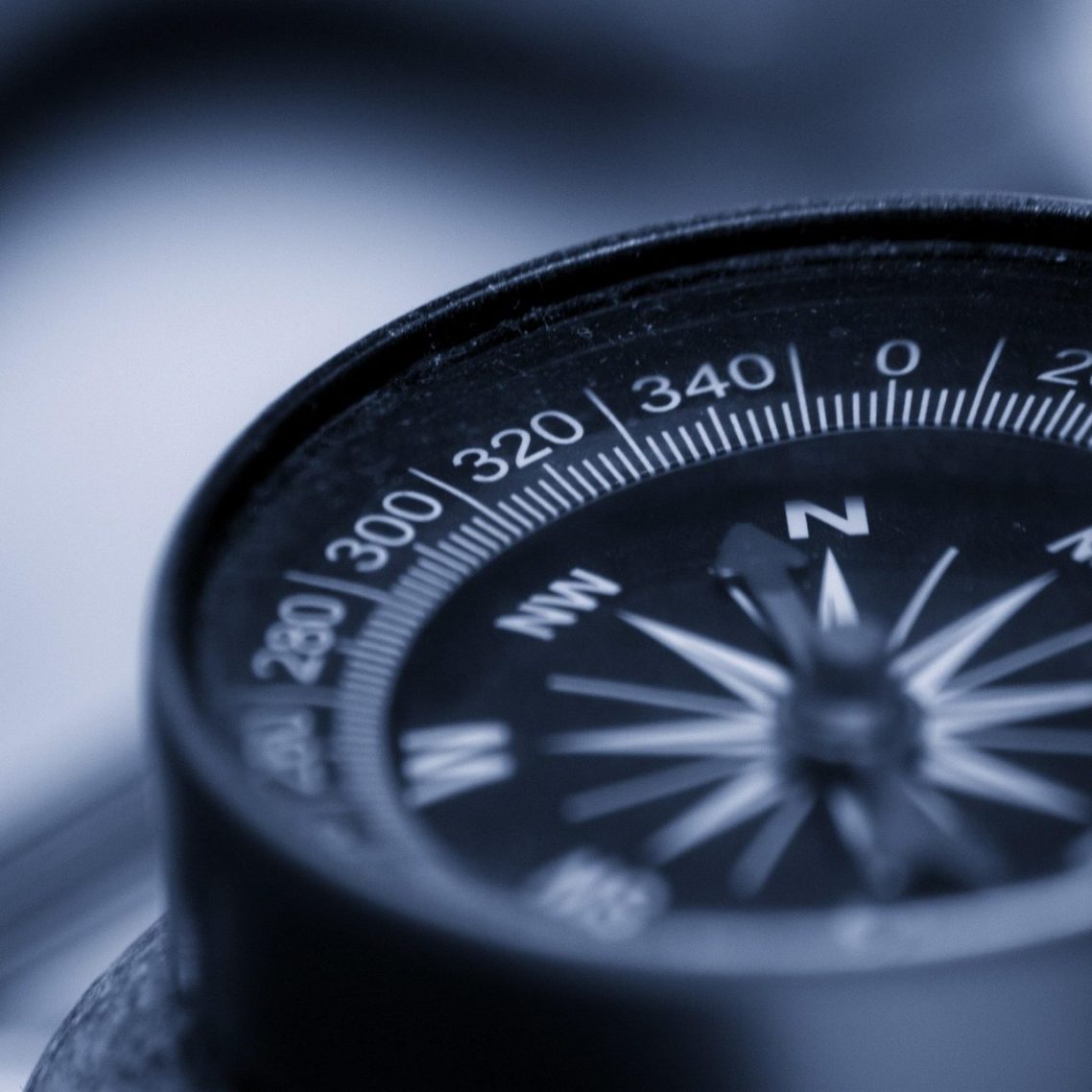 Schwarzer Kompass mit weißer Schrift als Symbol für Orientierung, das Finden des eigenen Tempos und die Stärkung der inneren Wahrnehmung.